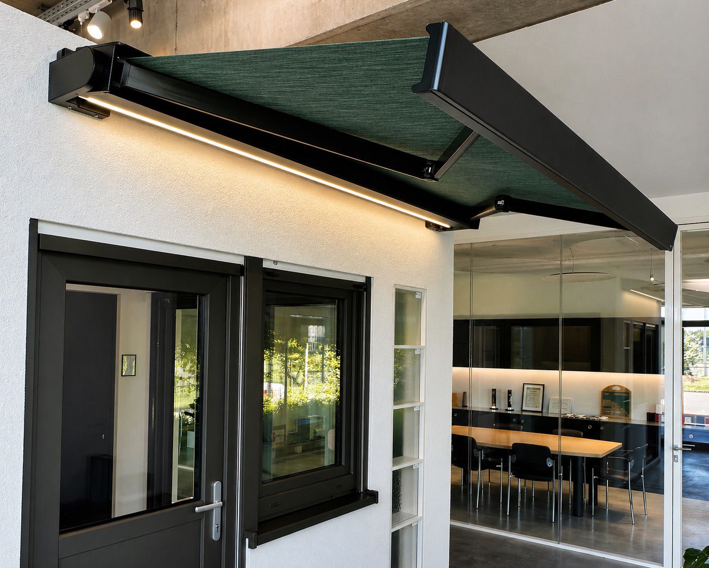 Store banne à bras articulés déployé au-dessus d'une porte-fenêtre