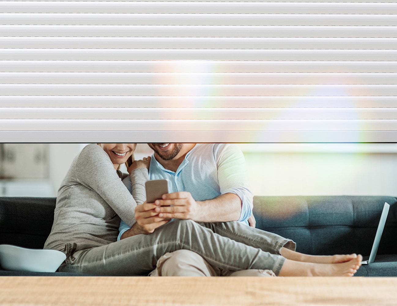 Couple détendu dans un salon avec volets roulants partiellement fermés