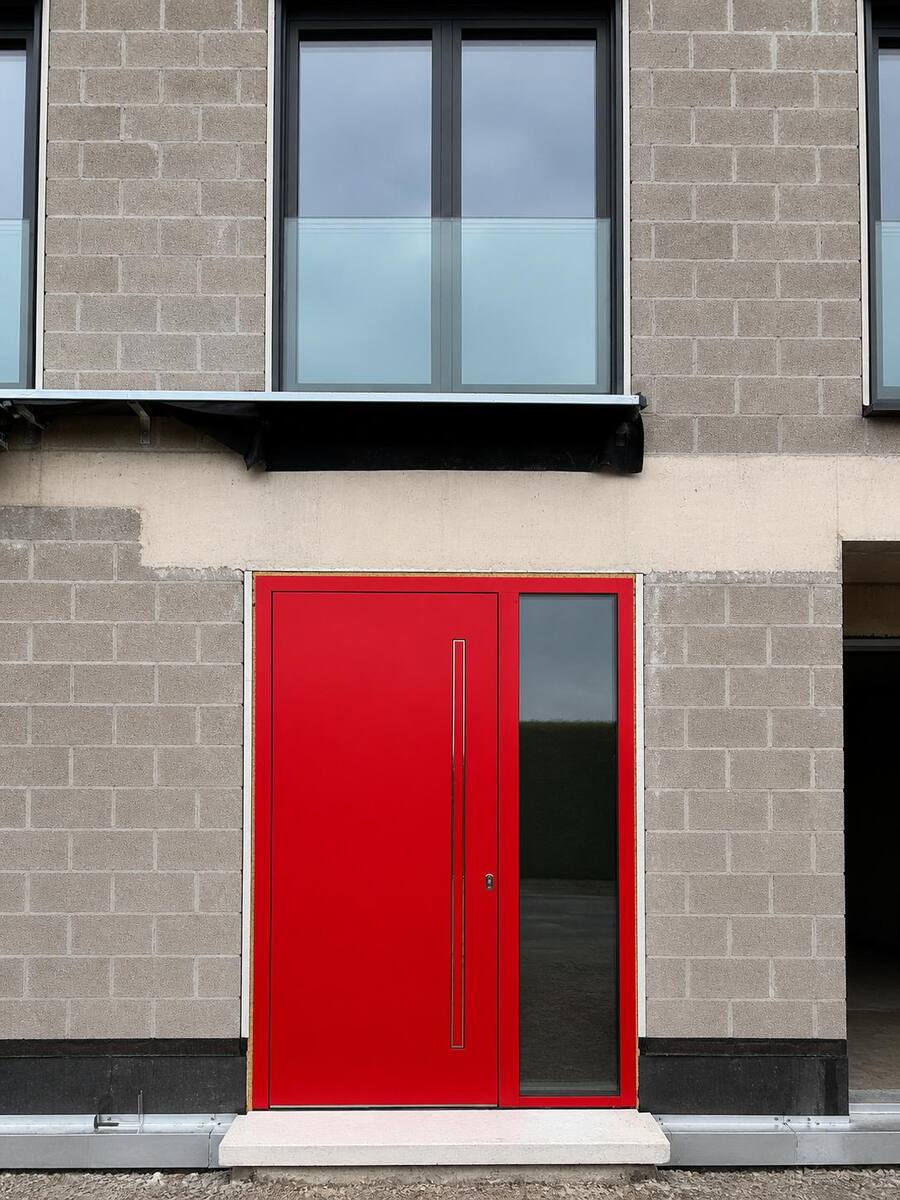 Porte d'entrée rouge sur un chantier en cours