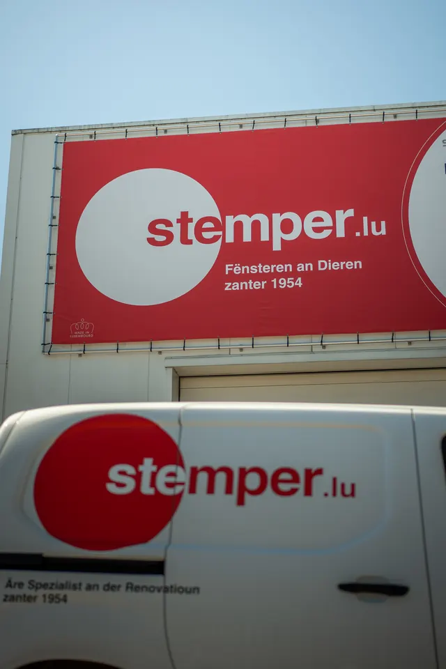 Enseigne stemper.lu au-dessus des portes de garage du bâtiment